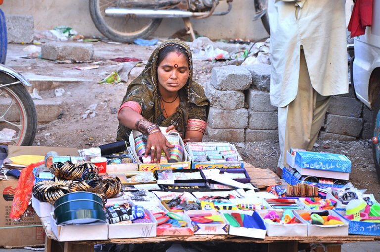 A woman displaying wearing items to attract the customer at Market road