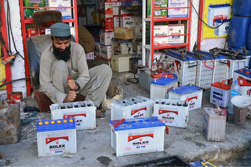 A technician repairs used batteries at a workshop to extend their service life